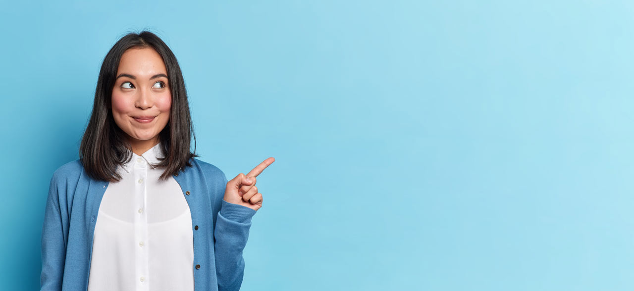 junge Frau lächelt und zeigt mit dem Finger nach links