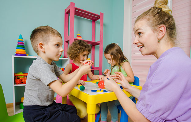 eine Frau und zwei Kinder spielen mit Spielzeug