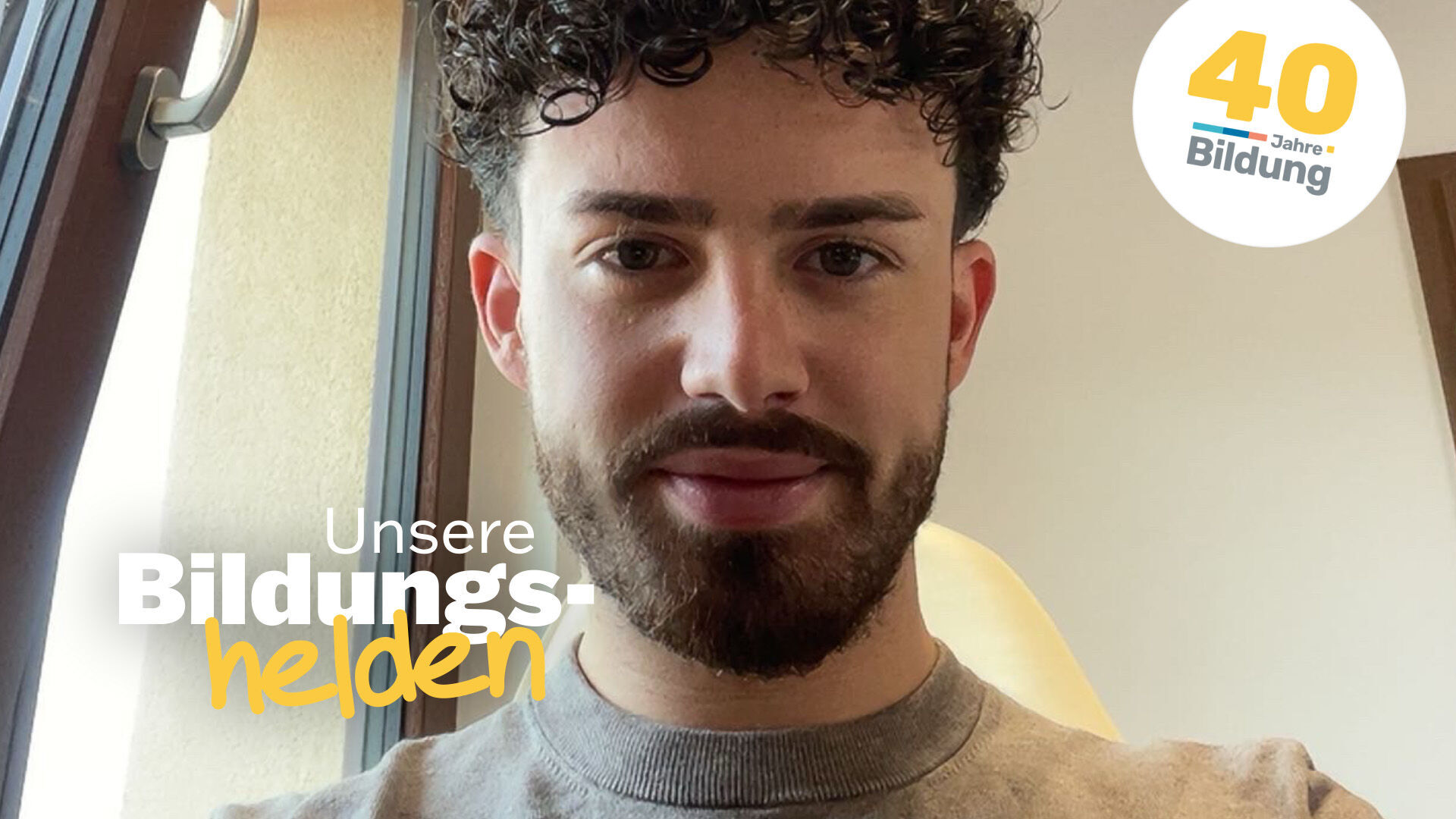 Video-Vorschaubild aus der Reihe "40 Jahre IBB - Bildungshelden": Stefano Bulla, Weiterbildungsteilnehmer beim IBB, in einem gut beleuchtetem Raum mit gekipptem Fenster.