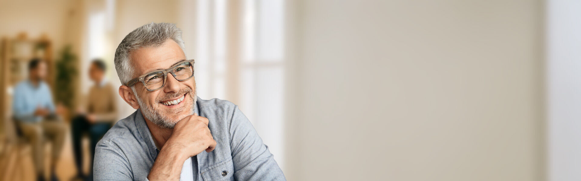 ein Mann mit Brille lächelnd, während er die Kamera anschaut