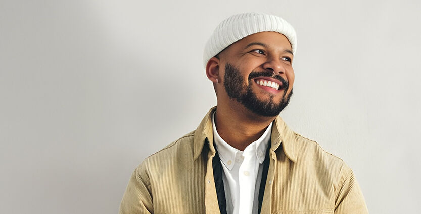 Junger Mann blickt lächelnd zur Seite